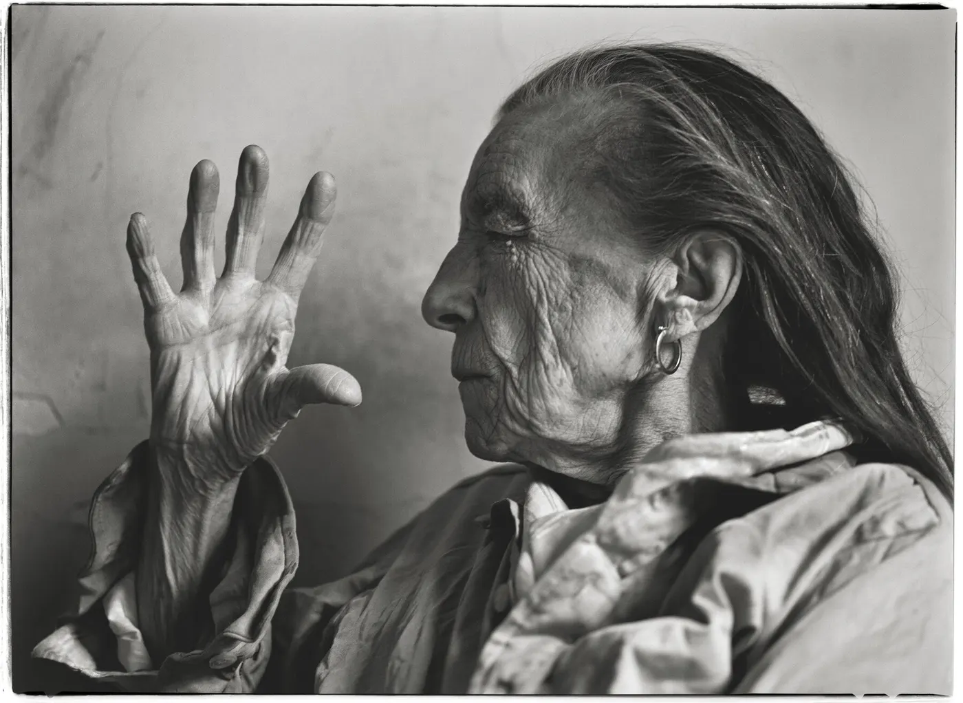 Louise Bourgeois in profile with one hand raised beside her face in Annie Leibovitz's black-and-white portrait